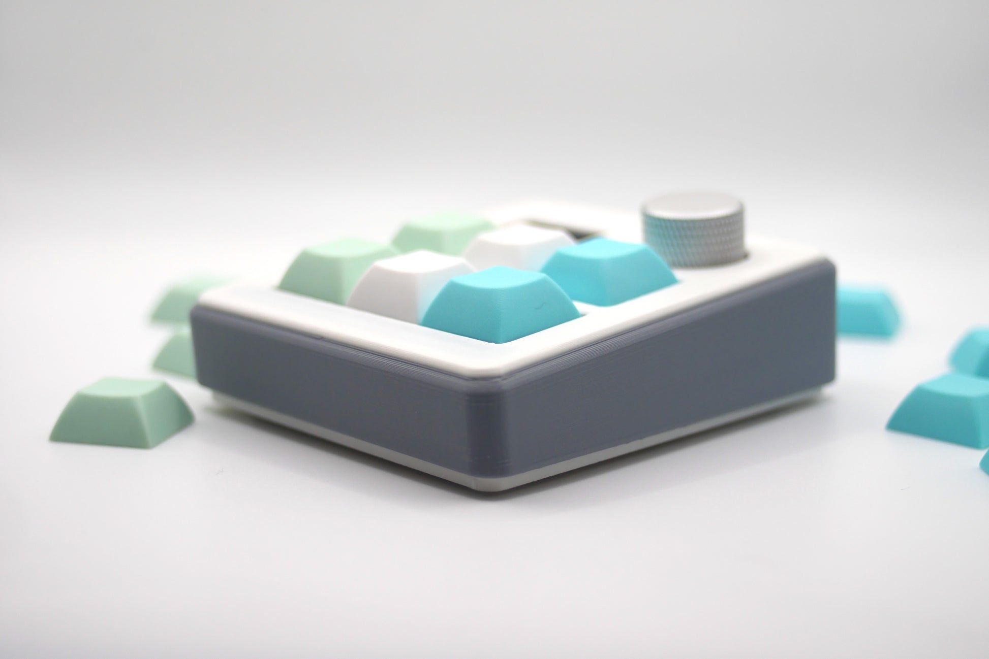 TogKey Pad Plus gray macropad with six pastel keycaps and silver rotary knob showing the side view