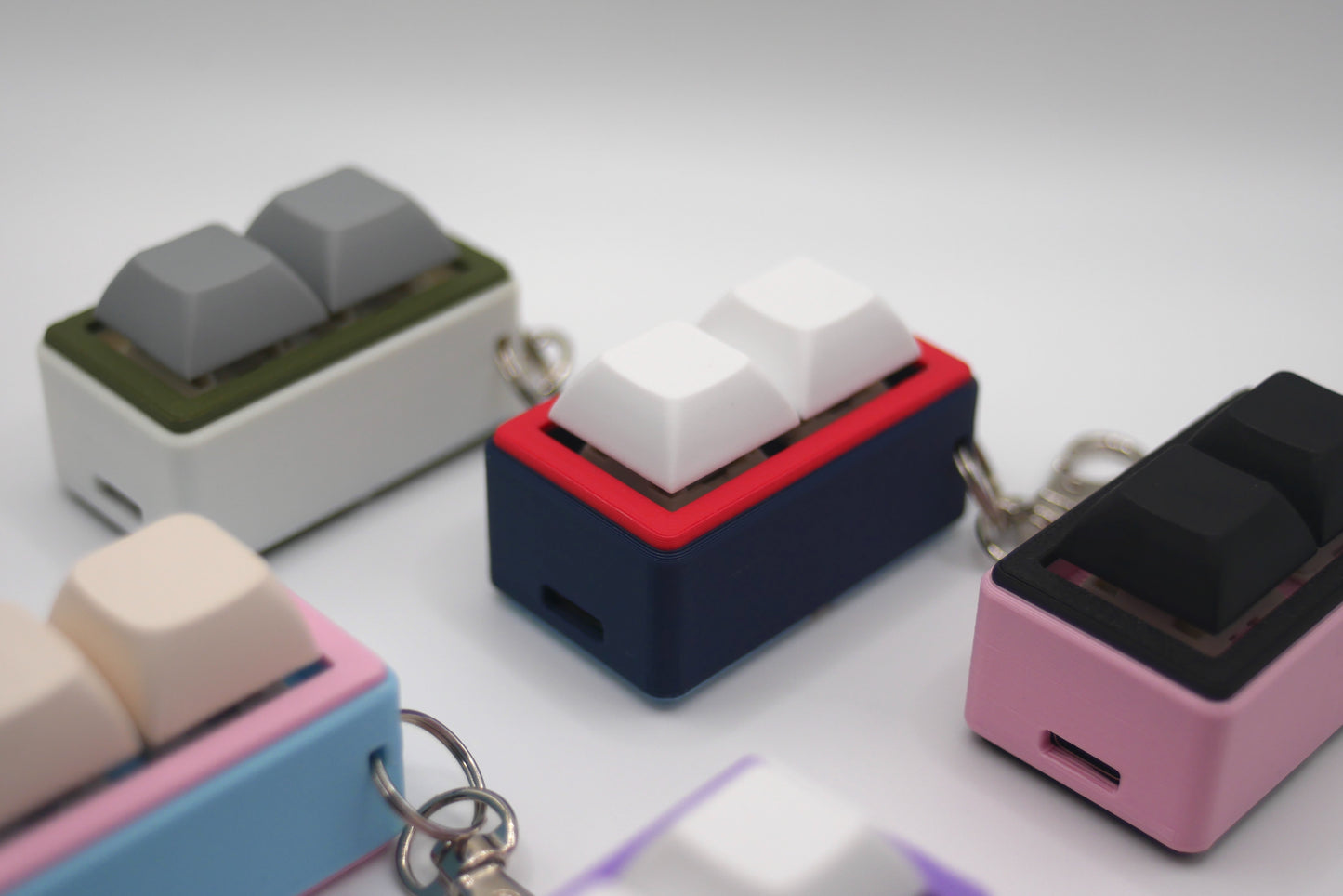 5 TogKey Pad Pocket Compact Customizable macropads in multiple colorways including pastel and dark colors featuring a Navy Blue and Red macropad in the middle