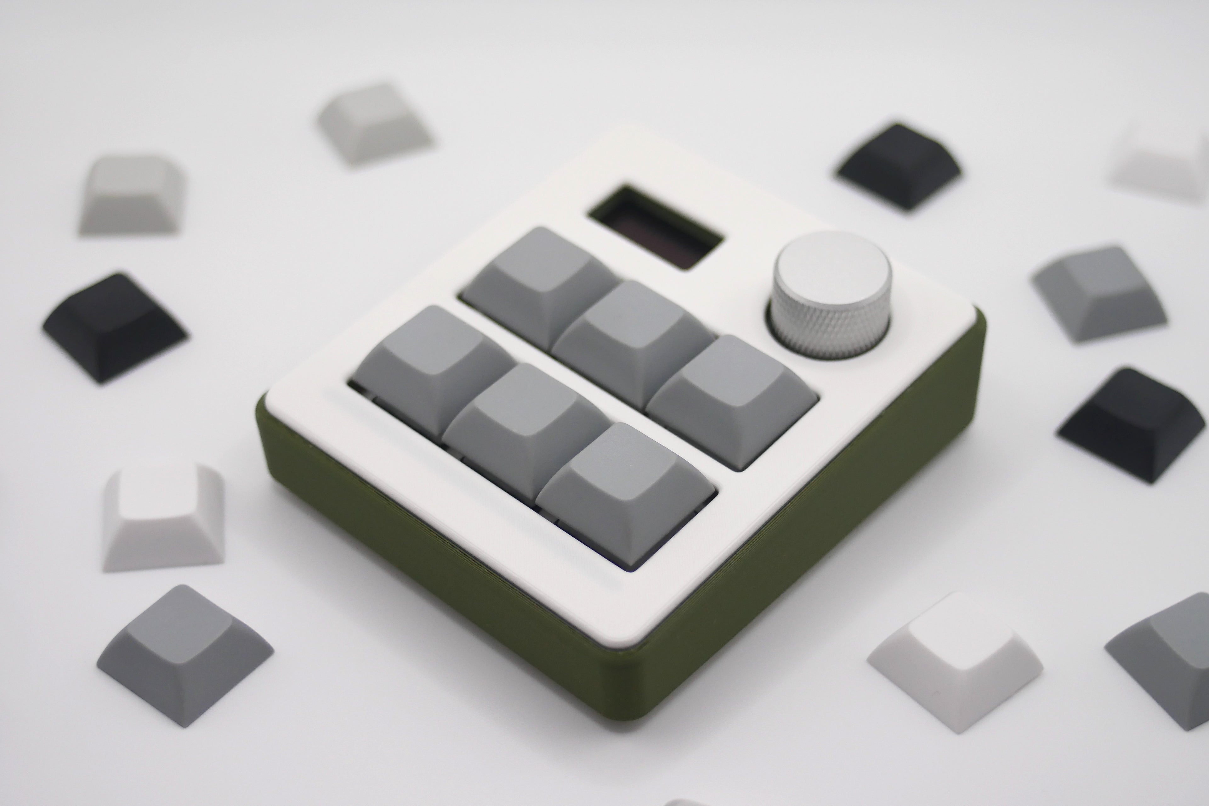 Close-up of TogKey Pad Plus top: hot-swappable switches and stealth RGB strip with knob and screen