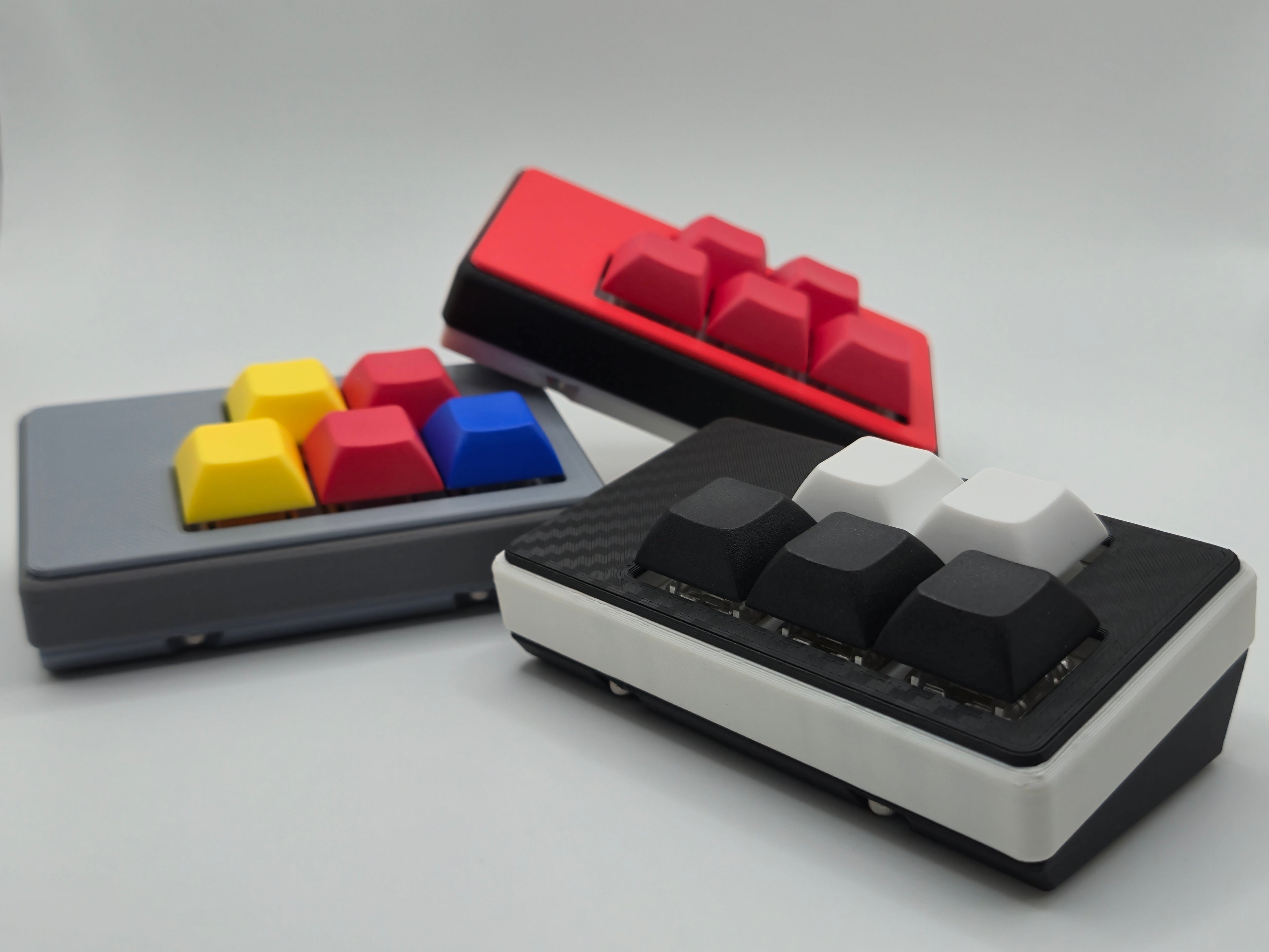 Three special edition macropads in various themes including retro, carbon fiber, and monster trainer made by TogKey