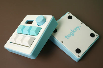 Togkey programmable macropad front and bottom view showing white and light blue 3d-printed case rubber feet and encoder knob