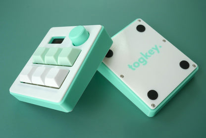 Togkey programmable macropad front and bottom view showing white and mint green 3d-printed case rubber feet and encoder knob