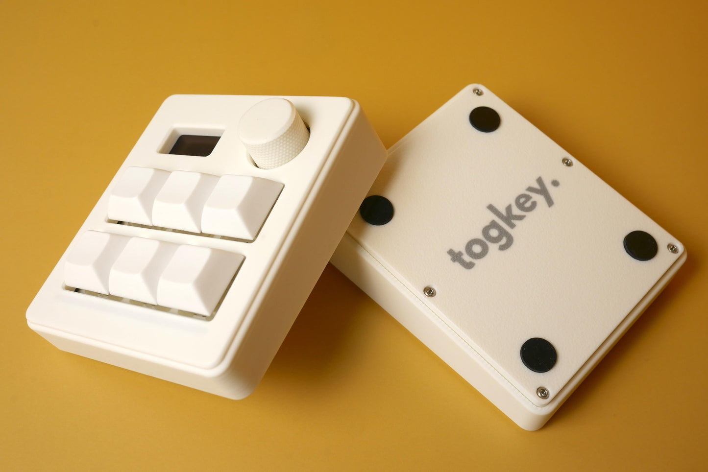 Togkey programmable macropad front and bottom view showing white 3d-printed case rubber feet and encoder knob