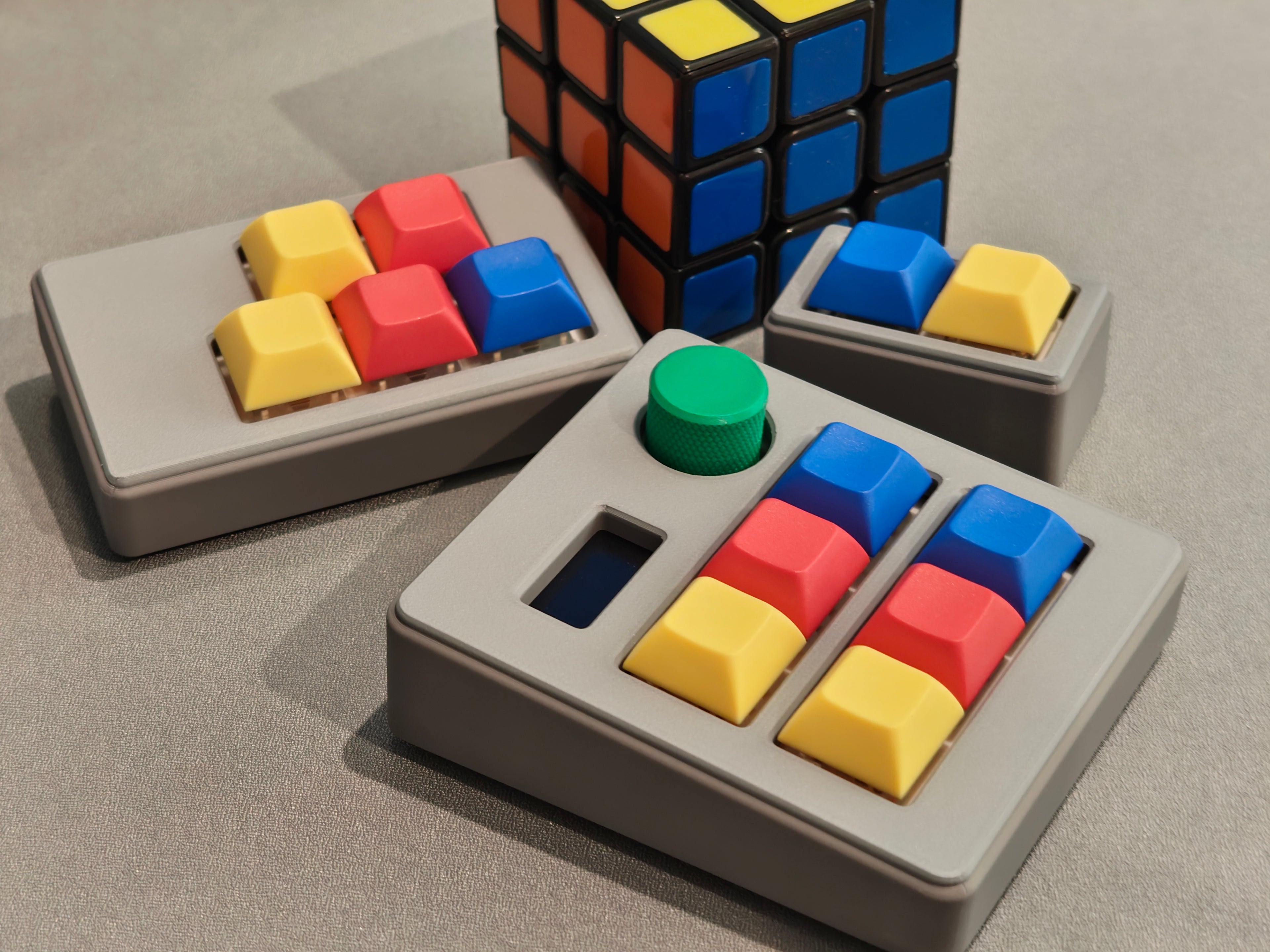 Colorful keycaps on a gray base with a Rubik's Cube in the background